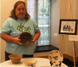 girl holding piece of pottery surrounded by other art pieces